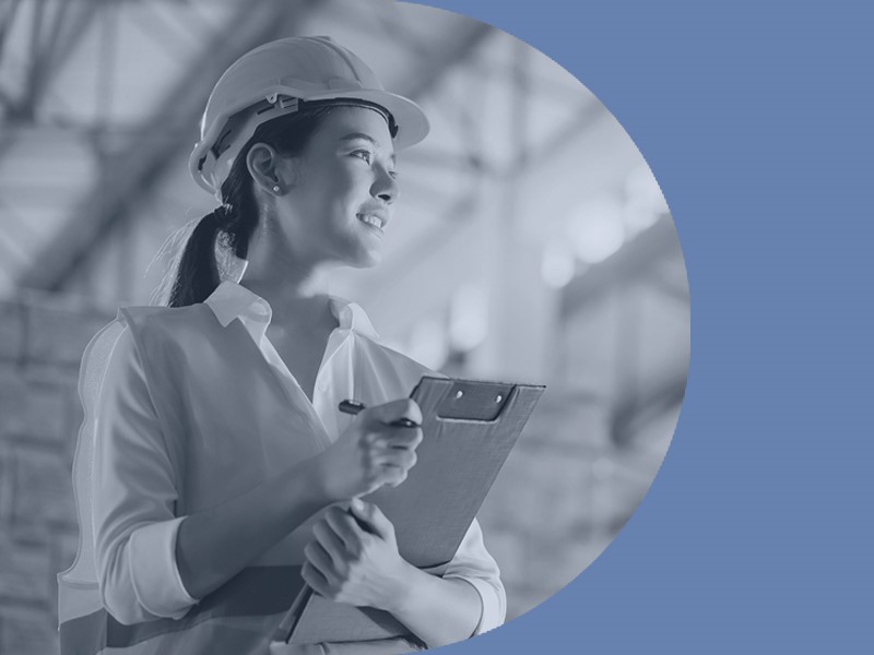 Woman in PPE with clipboard.